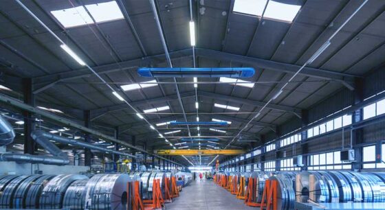 Innenansicht einer modernen Industriehalle mit Stahlrollen.