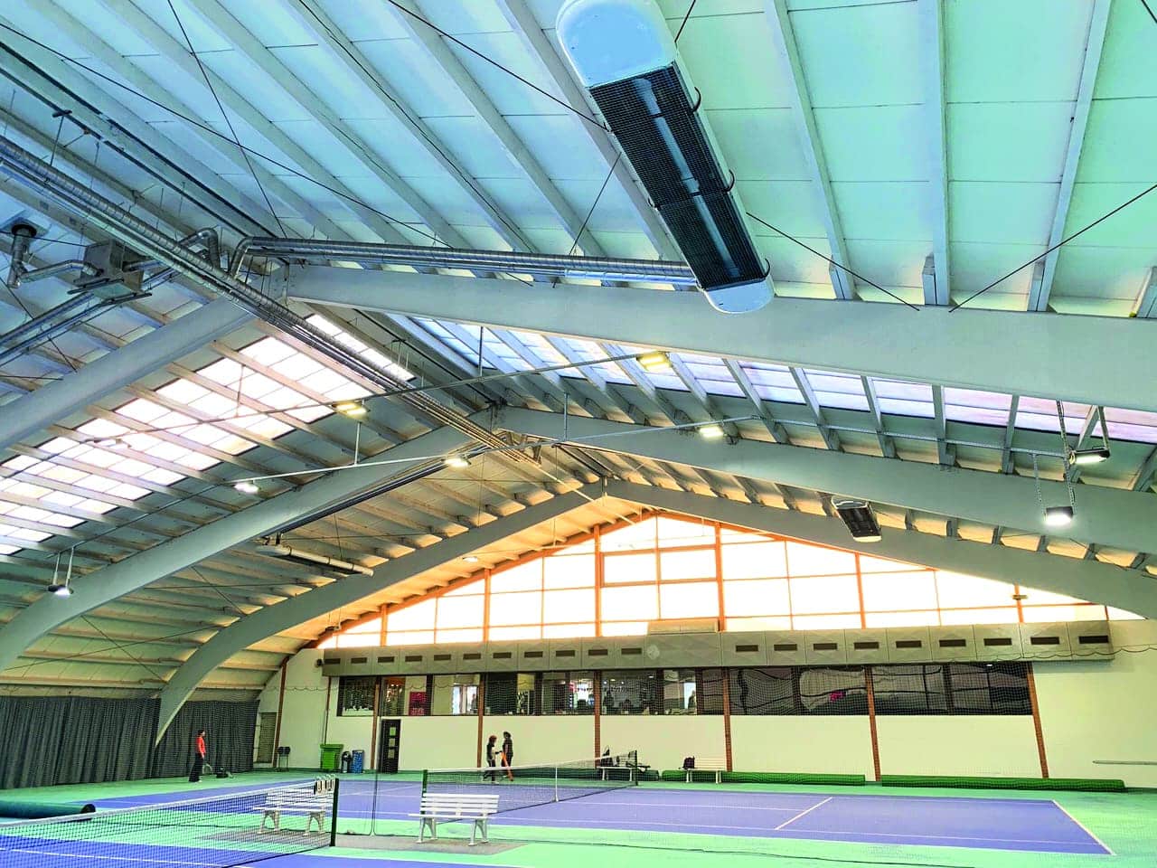 Innere Ansicht einer Tennishalle mit natürlichem Licht.