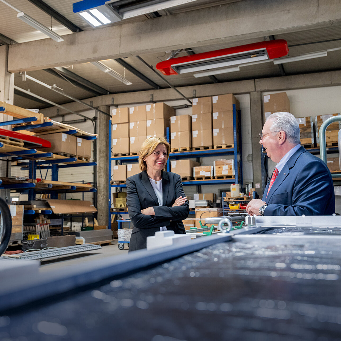 Managing director and employee in a warehouse discussion.