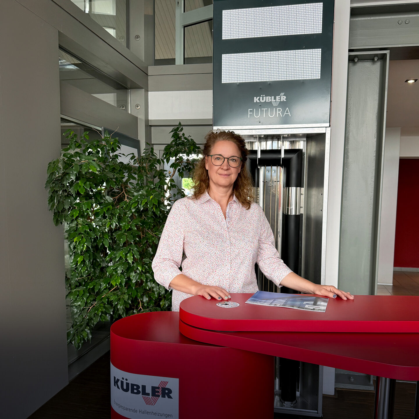 Woman standing at reception desk of Kübler company.