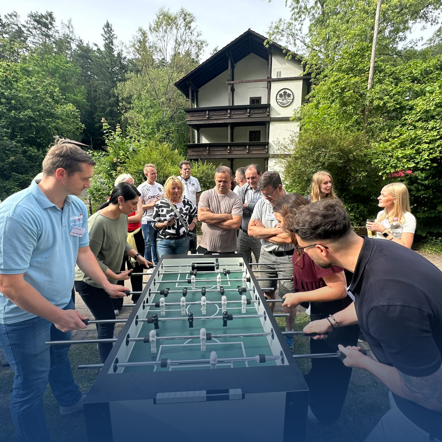 Group plays table soccer outdoors.