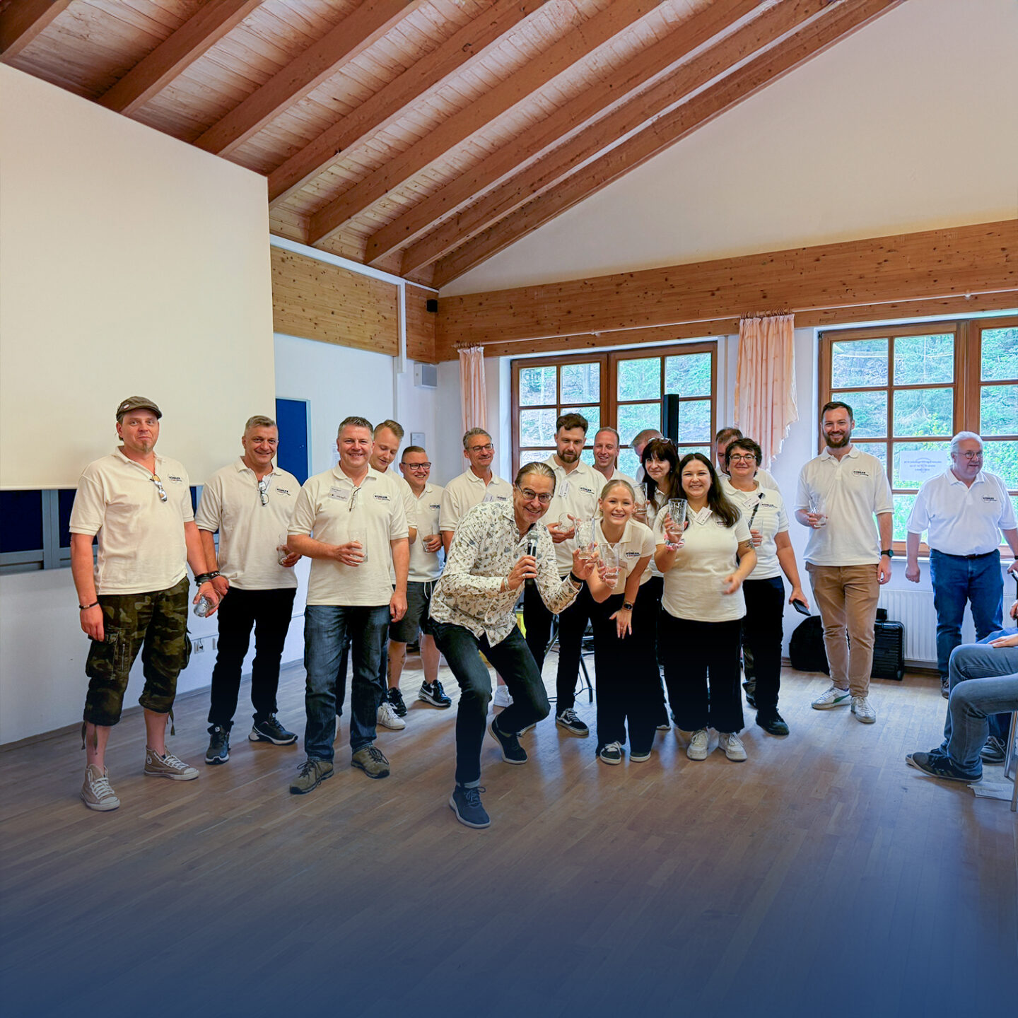 Gruppenfoto in hellem Seminarraum, Personen lächeln.