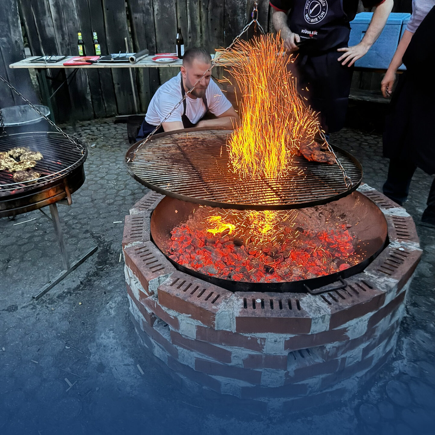 Man watches spectacular fireworks while barbecuing.