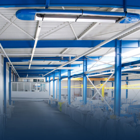 Leere Industriehalle mit blauen Stahlträgern.