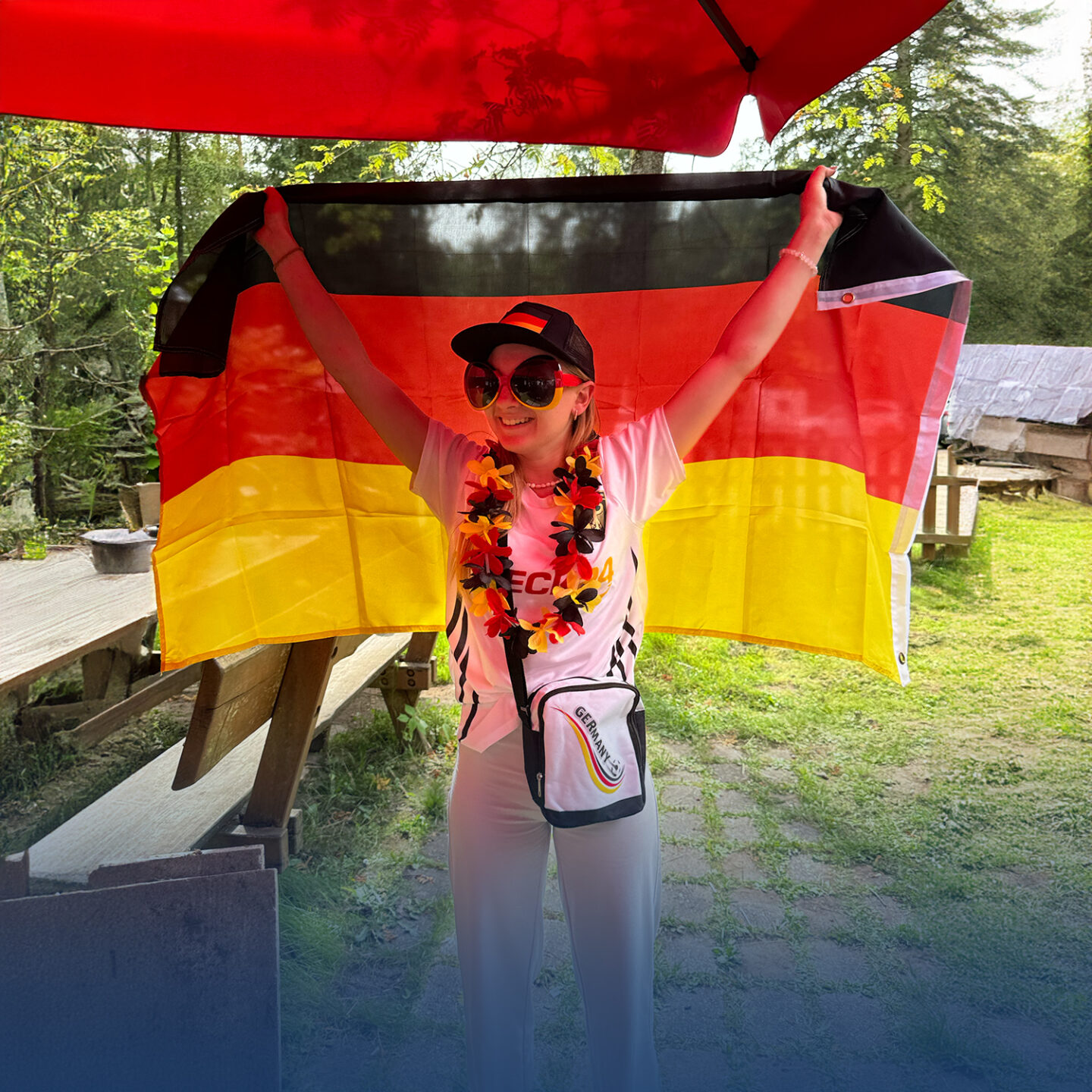 Frau mit deutscher Flagge und Fanutensilien.