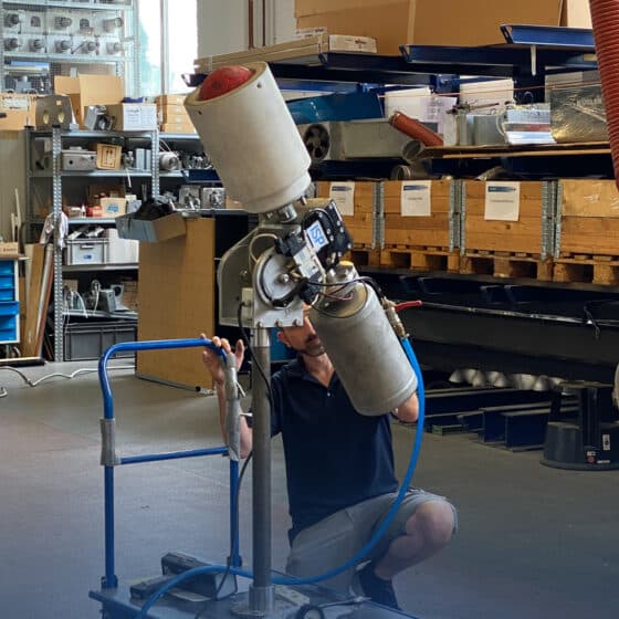 Man repairs large industrial robot in workshop