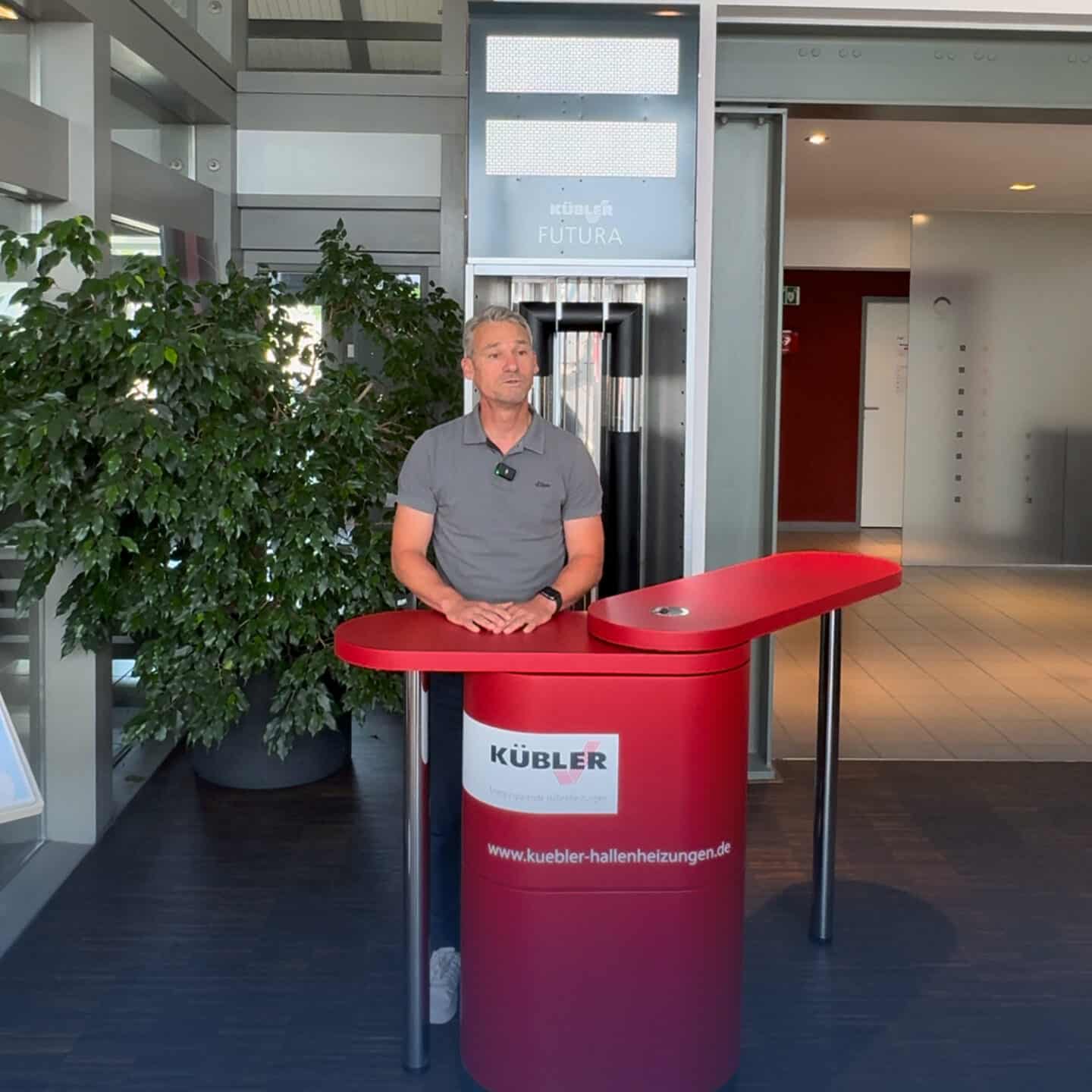 Man standing at the red reception desk in the office building