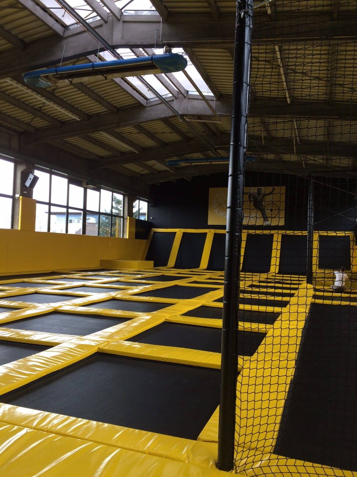 Large hall with yellow trampolines and nets