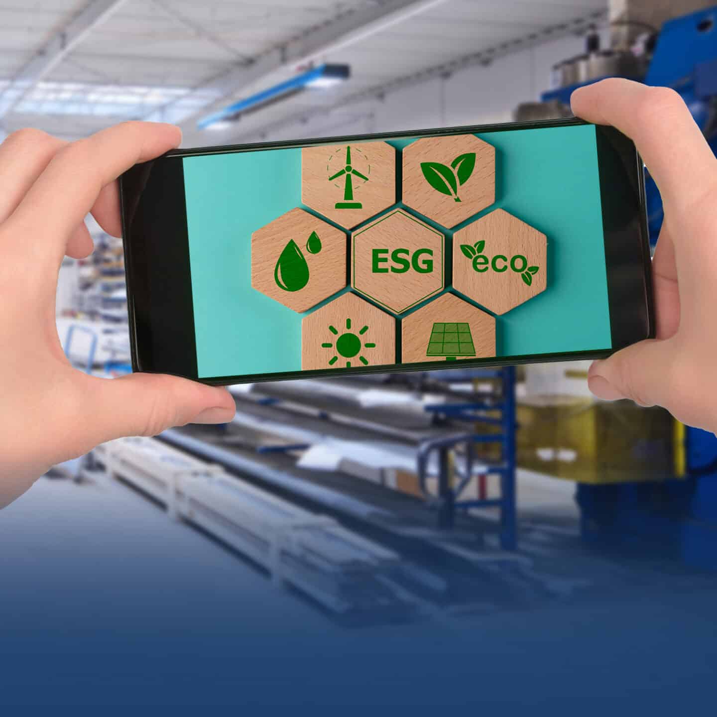 Cell phone shows ESG environmental symbols in factory environment