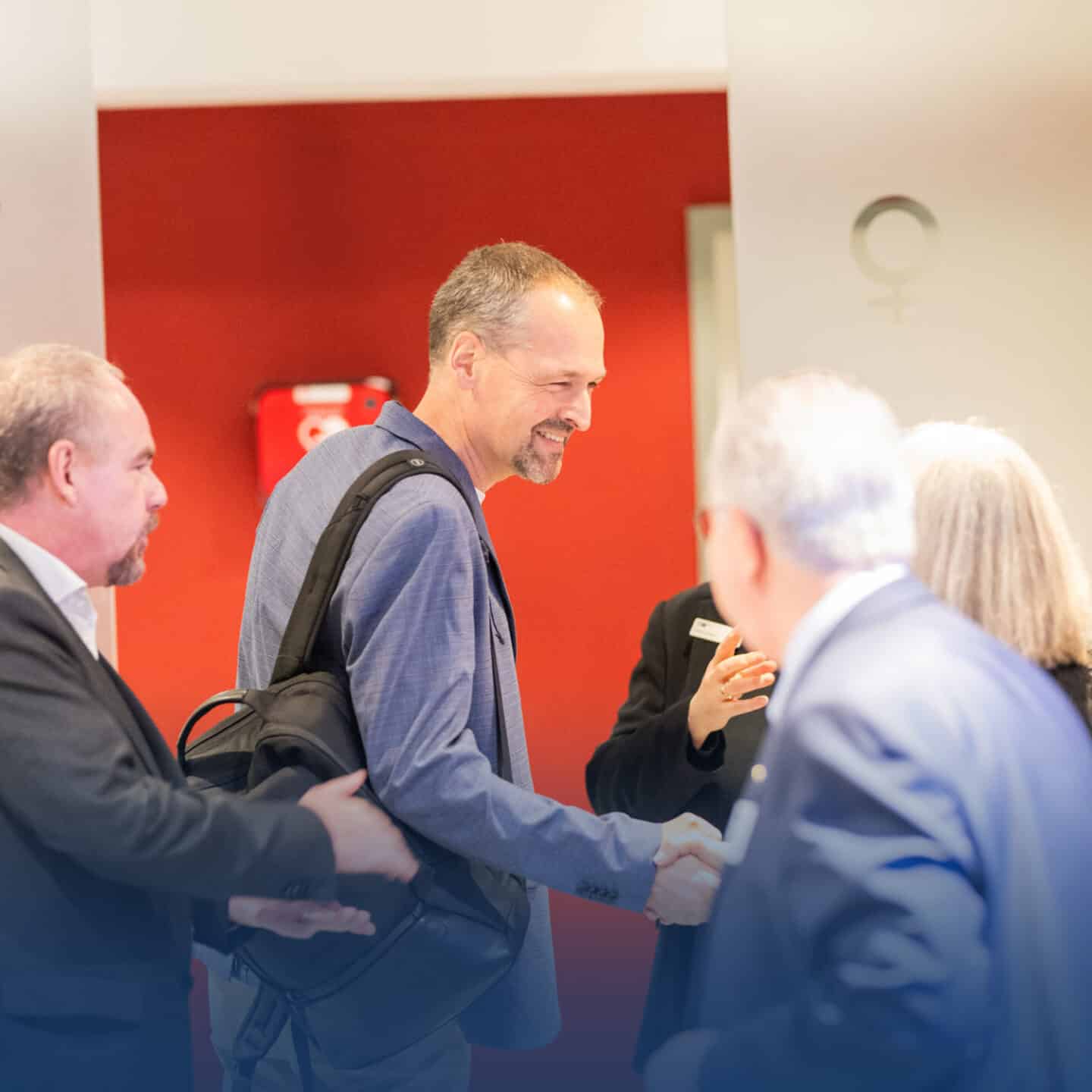 Men greet each other with smiles at business conferences