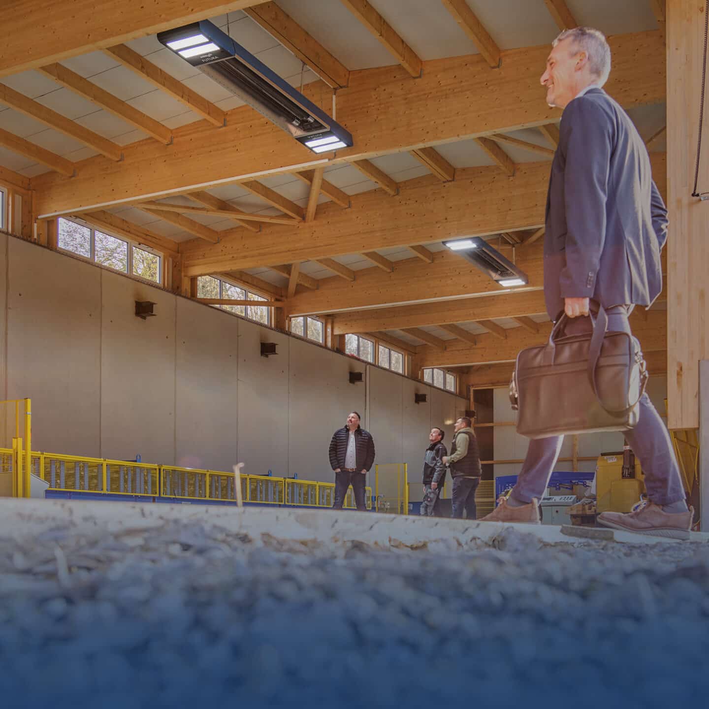 Man in suit enters industrial factory hall