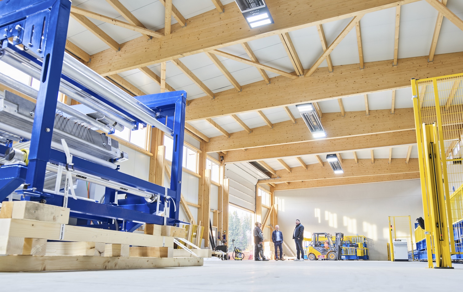 Employees in modern wood workshop with machines