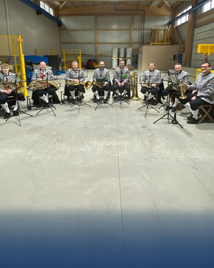 Brass band sits in an industrial hall