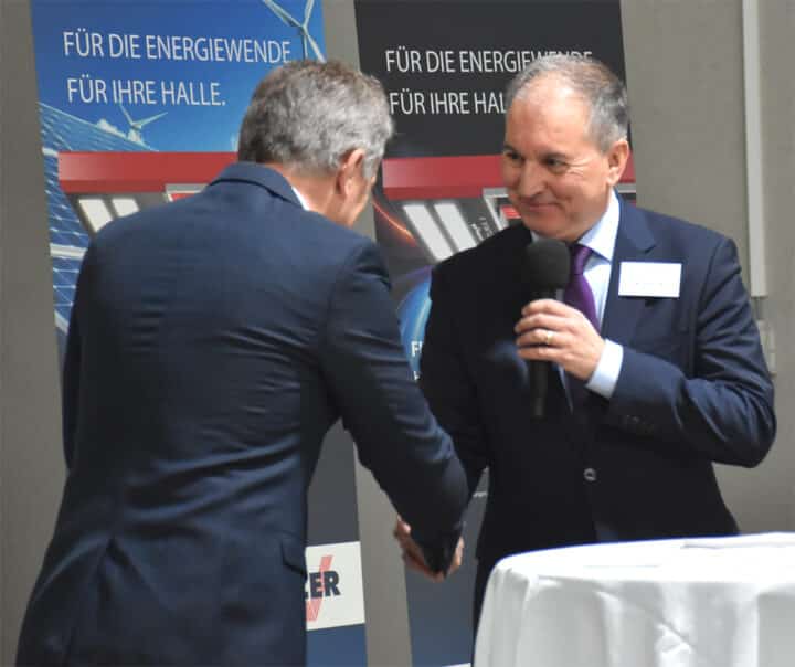 Two men shake hands at an event