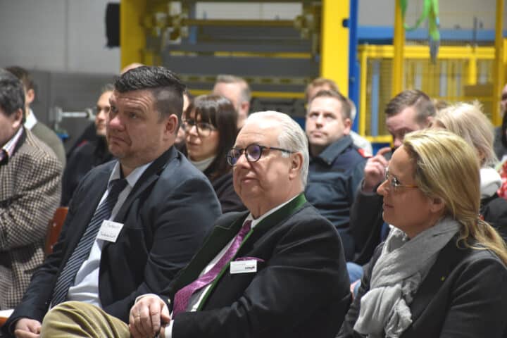 People listen to a lecture in an industrial hall