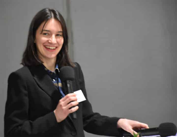 Smiling woman speaking at a microphone