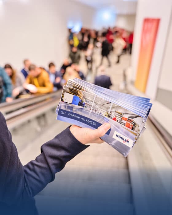 Person hält Broschüren auf Rolltreppe